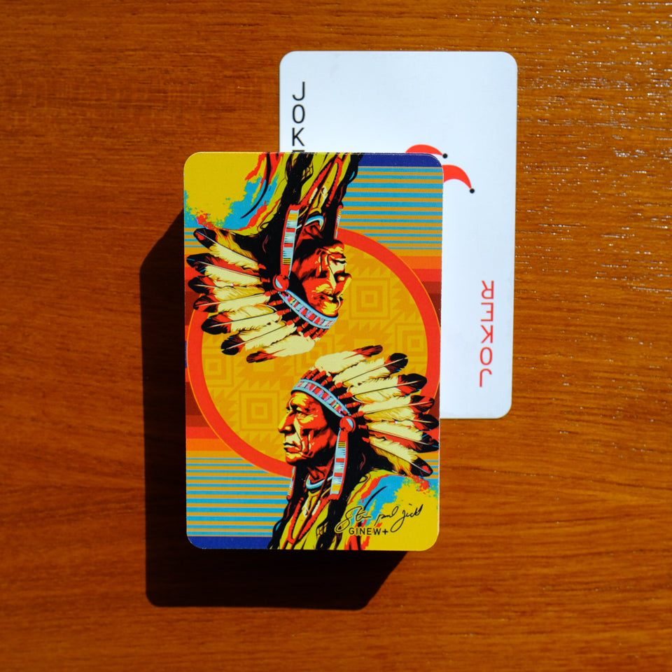 Full deck of Steven Paul Judd designed Sitting Bull Playing cards slightly fanned out on wood table with joker showing.