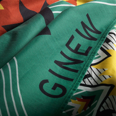 Close up of word GINEW on Large wild rag bandana with Eight point star design in green and yellow, white and black. 