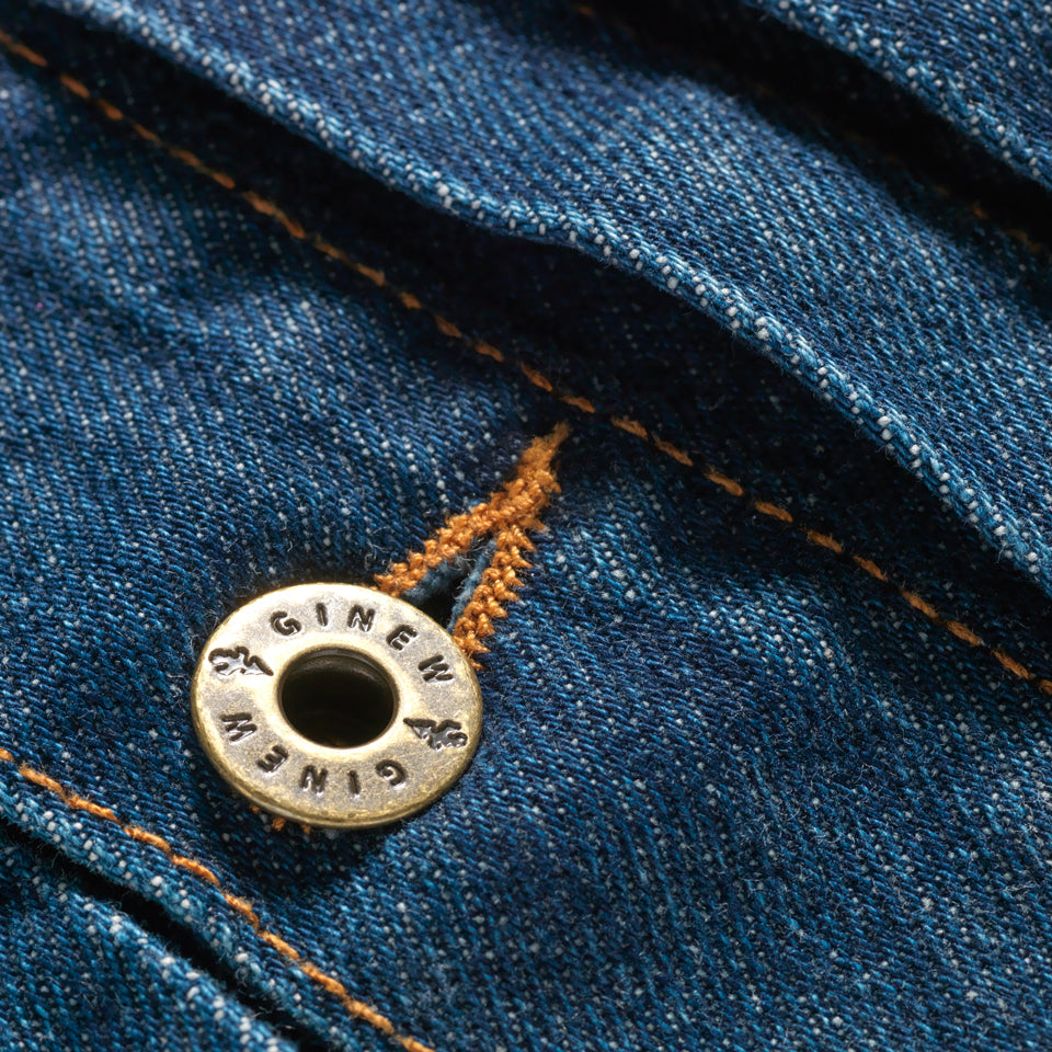 Brass hardware close up on Native American designed denim jacket from Ginew + Steven Paul Judd with smiling arrow patch on right arm and color band at chest pocket