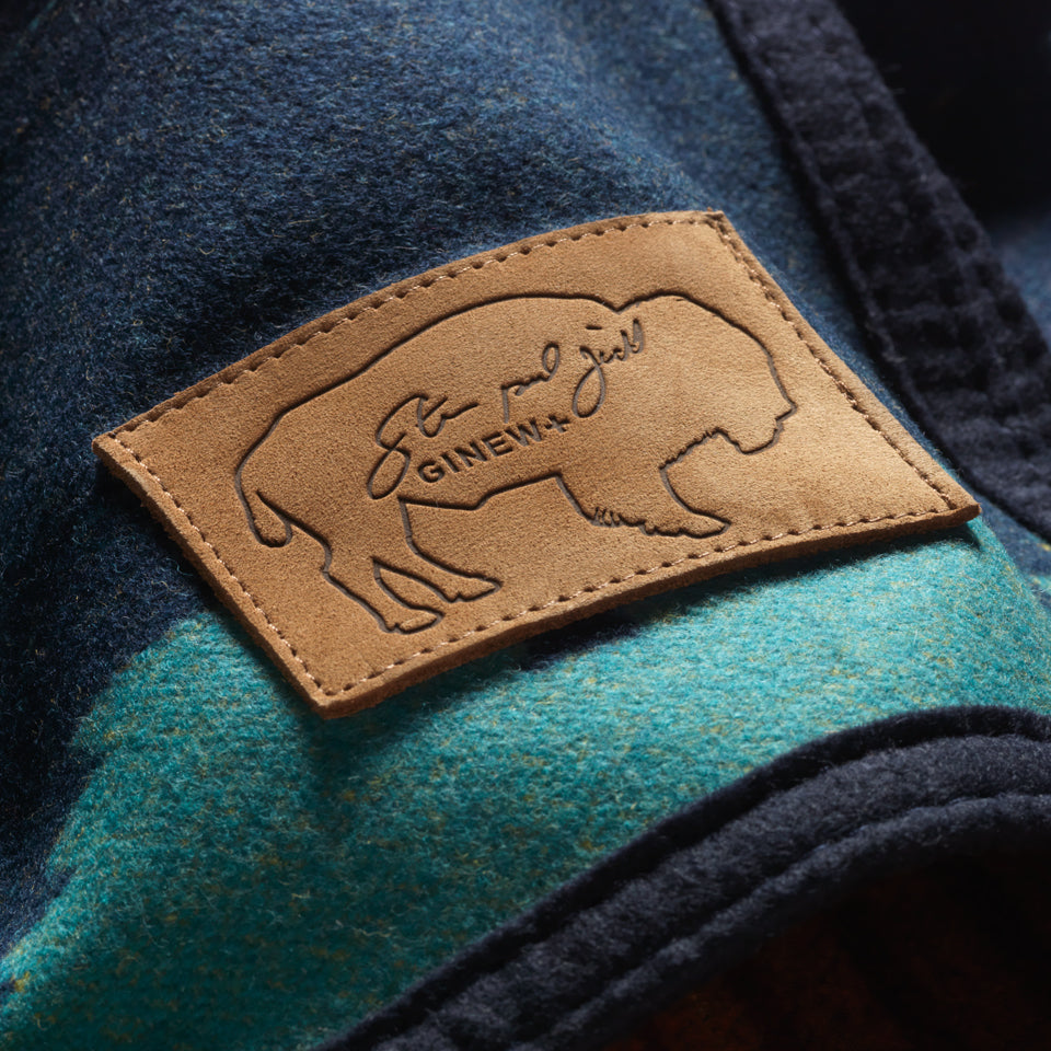 Close up of leather buffalo  patch with Steven Paul Judd's signature + Ginew on Cotton Wool blend blanket of Sitting Bull designed by Steven Paul Judd and Ginew