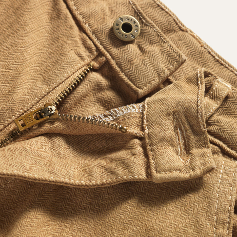 Detail view of zipper-fly and button on the waist of the Superior Pant in Khaki.