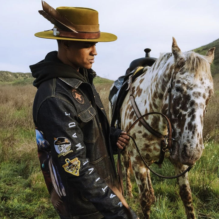 Male model in Native American Ginew denim jacket and hat collab with Thundervoice hat co. 