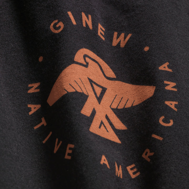 Made in USA black tee with close up of front design of Ojibwe thunderbird in copper with words Ginew Native Americana 