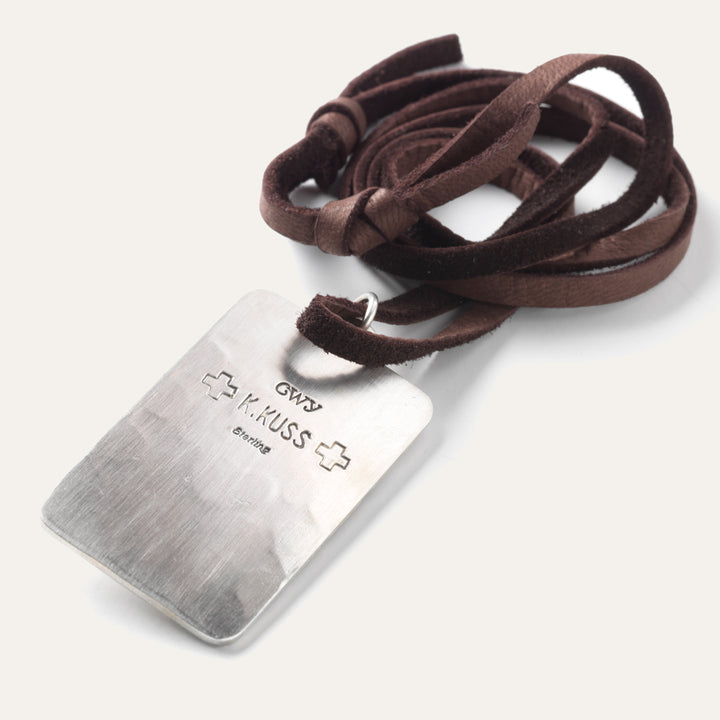 Back of silver pedant tag necklace Native American made necklace with a Thunderbird design hangs on leather lace. 