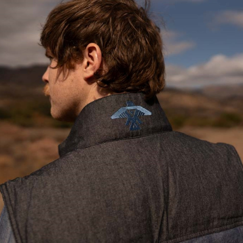 Close up of denim vest with Native American Ojibwe Thunderbird embroidery by Ginew on man in canyon