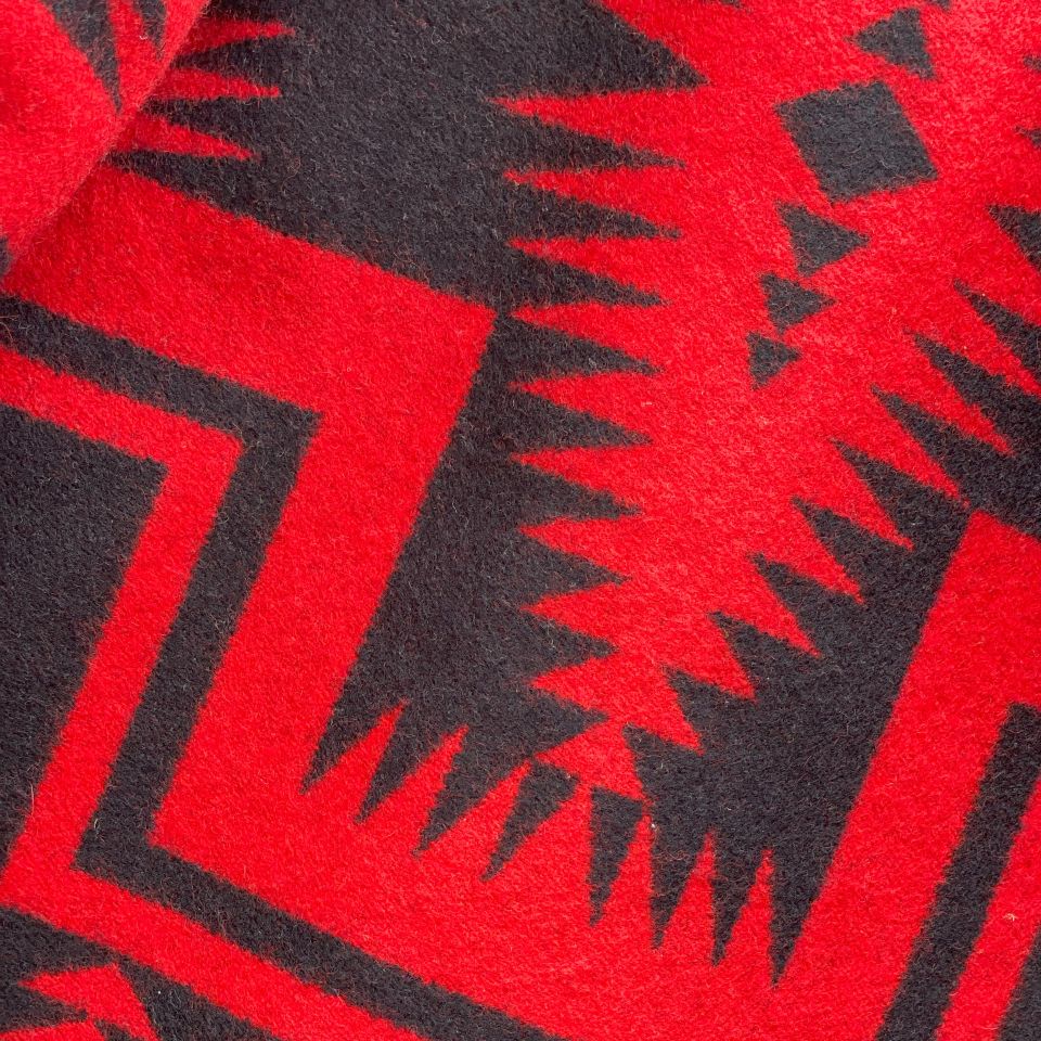 Close-up of red and black geometric patterned fabric on Charcoal grey rider coat lined with red and black Pendleton Walking Rock blanket lining 