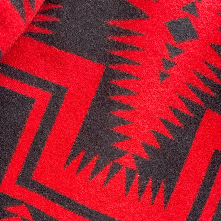 Close-up of red and black geometric patterned fabric on Charcoal grey rider coat lined with red and black Pendleton Walking Rock blanket lining 