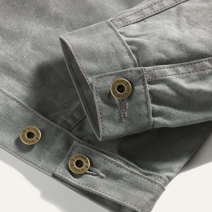 Detail view of sleeve cuff hardware and adjustable button on back hem.