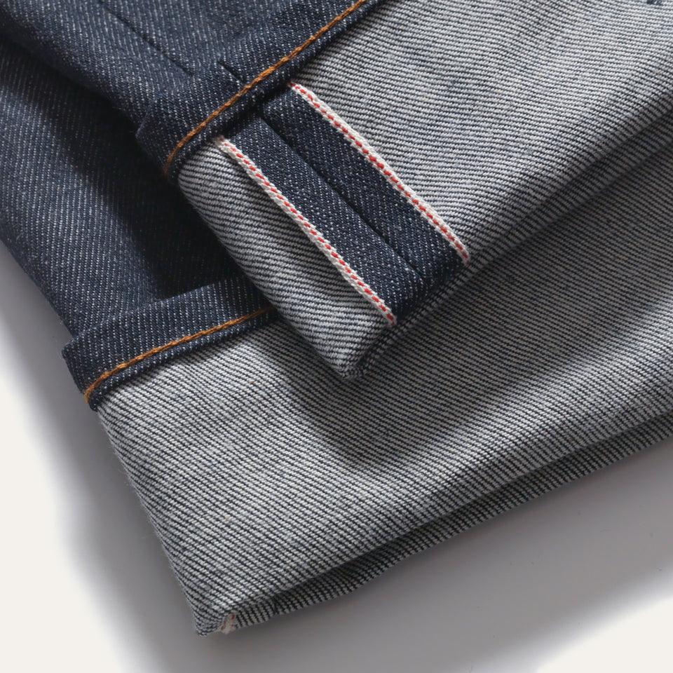 Made in USA Selvedge denim bottom hem, jean is cuffed exposing inside seam.