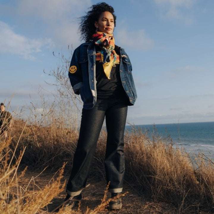 woman at coast wearing a custom deadstock denim jacket by Ginew