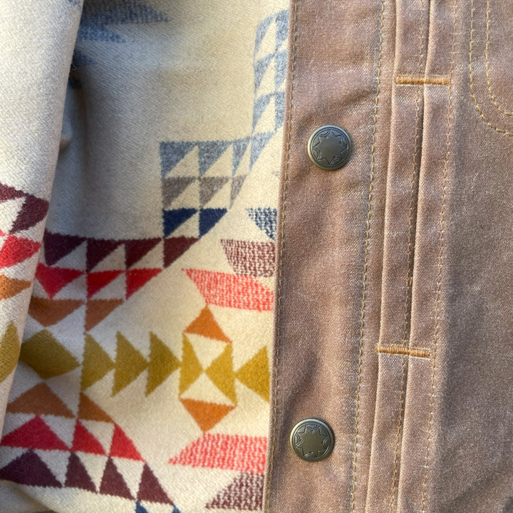 Close up of Women's brown wax canvas coat with colorful, southwest Pendleton wool lining with Native American Ginew tag