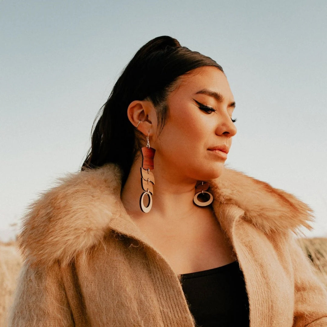 Indigenous woman wearing Native American hand made mixed wood earrings 