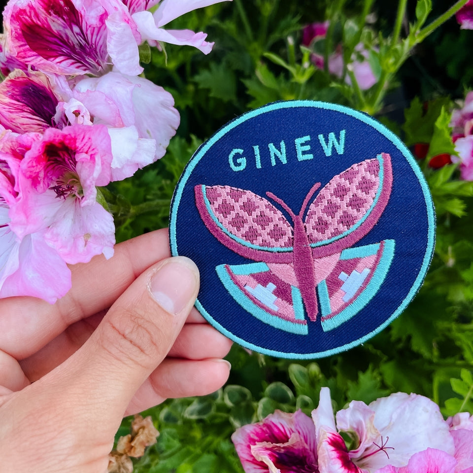 Butterfly patch in pink and green with blue background by flowers