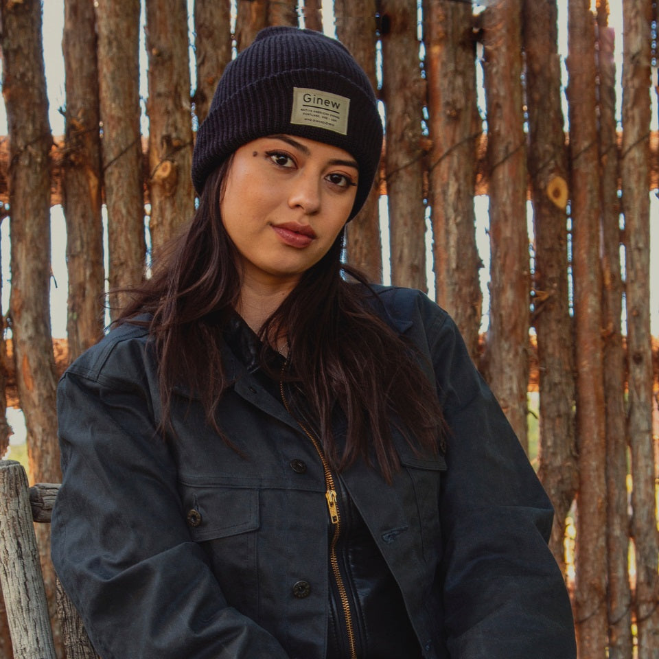black merino wool watch cap made in USA by Ginew. Cap on Native American model outdoors.