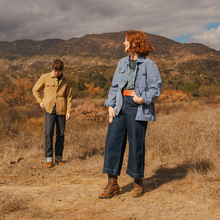 All gender barn jackets in blue and tan on couple in nature