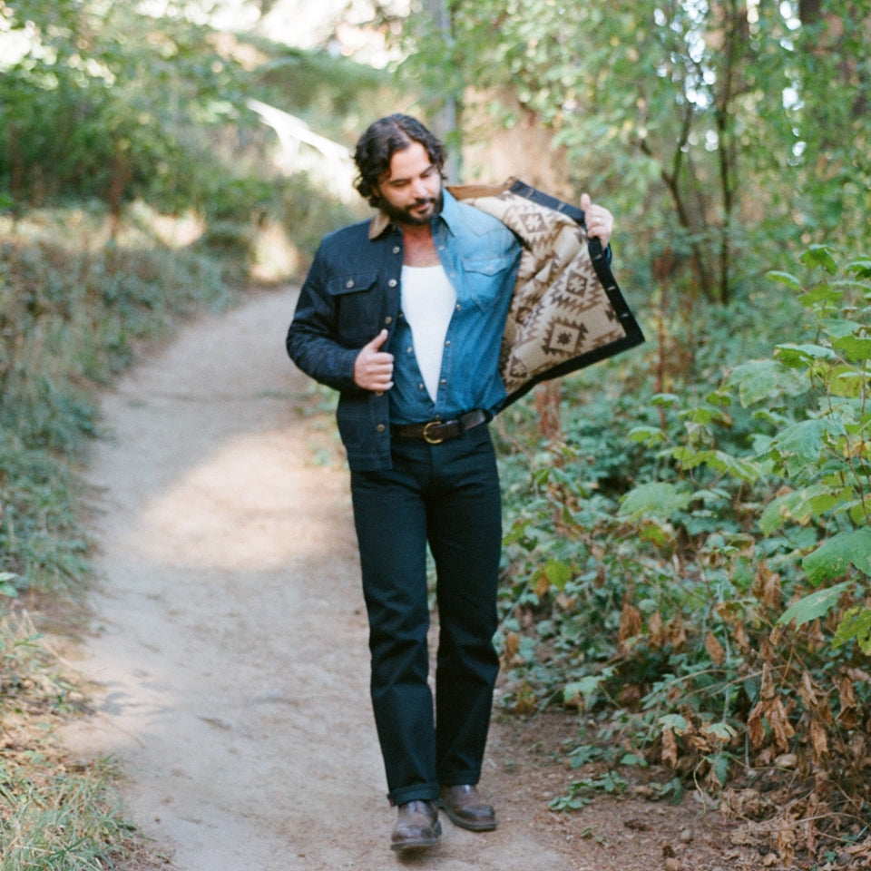 Man wearing Ginew denim coat and selvedge denim jeans in black 