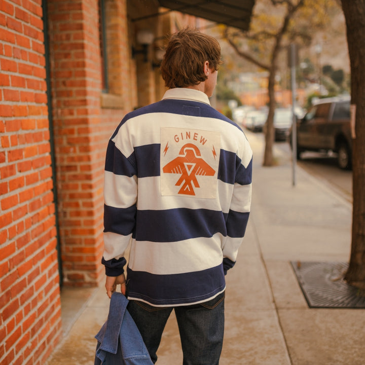 Man wearing Navy and cream stripe rugby with Ginew's Thunderbird on back 