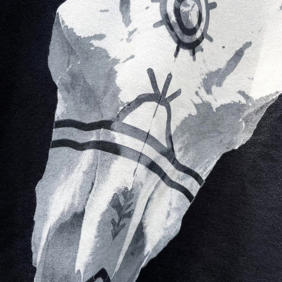 Close up of Black cotton t-shirt with buffalo bison skull on front and Ginew tag reading made in USA 