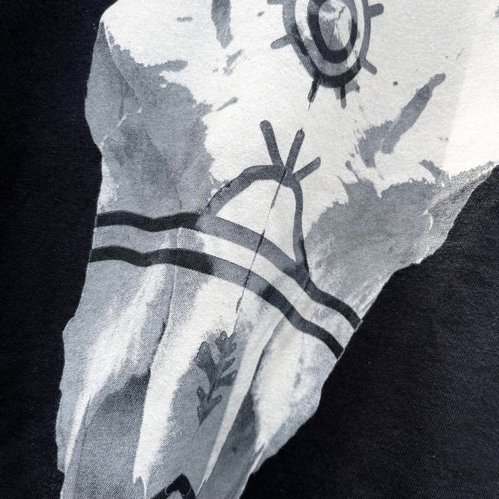 Close up of Black cotton t-shirt with buffalo bison skull on front and Ginew tag reading made in USA 