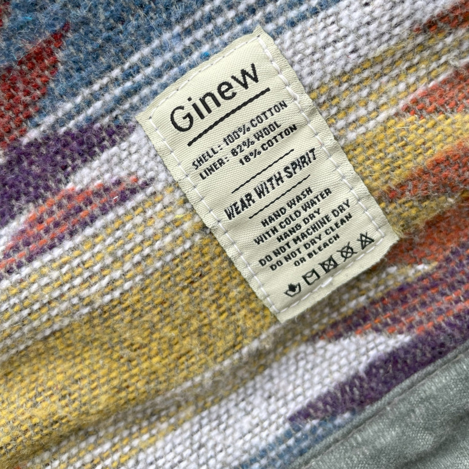 Care tag on Gray silver charcoal wool lined coat with a colorful Native American patterned lining by Ginew