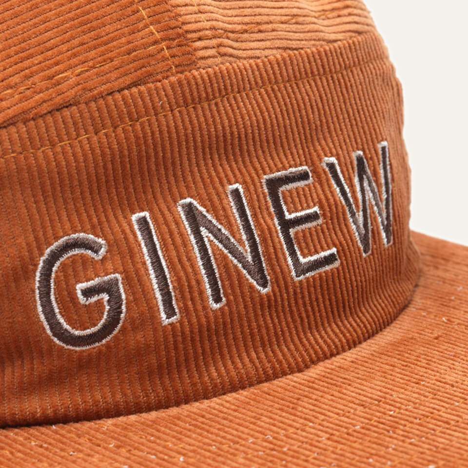 Close up of Embroidered text that reads: "GINEW" on front on Corduroy Camper Hat.