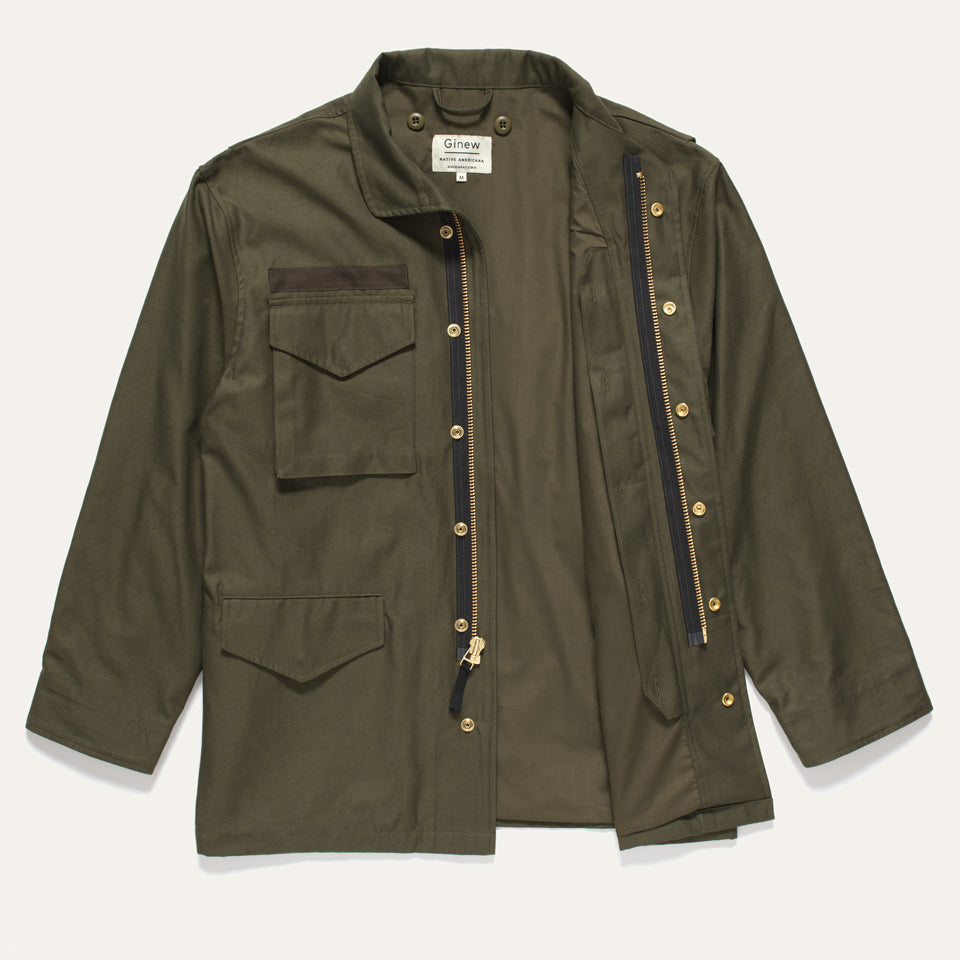 Military green coat with vest removed showing brass hardware and Ginew label. 