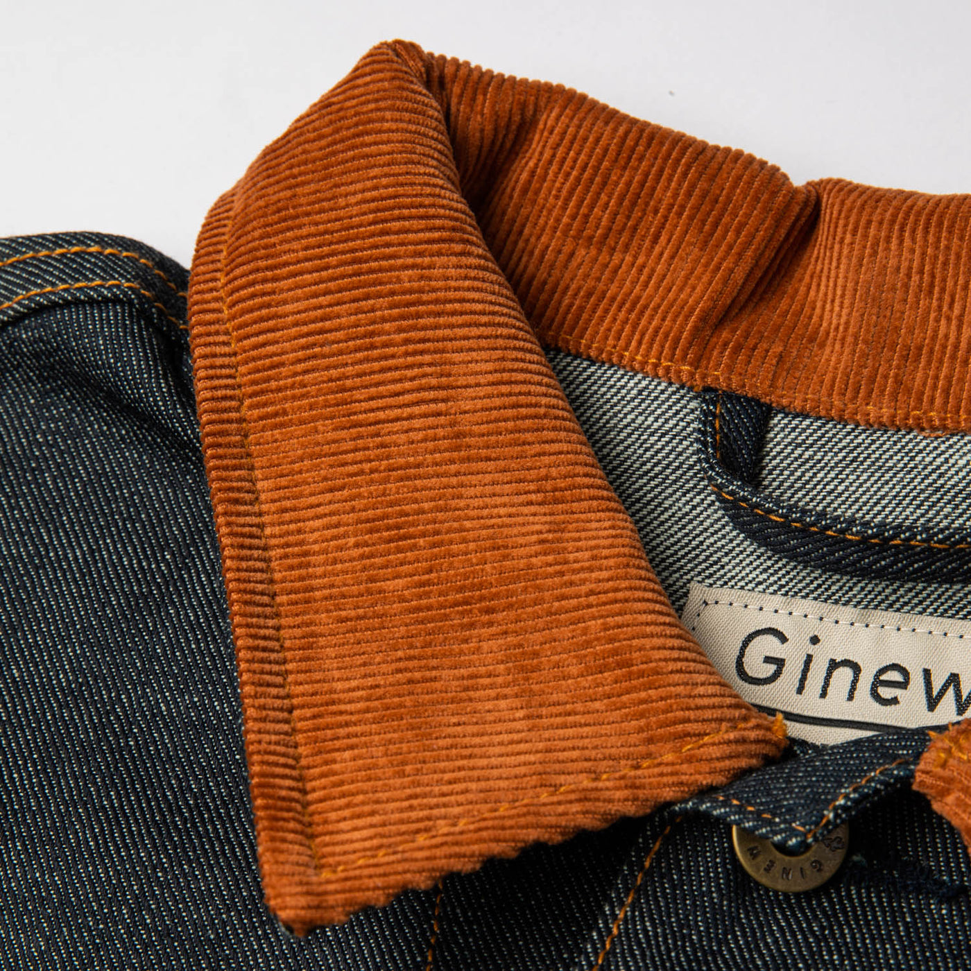  Close up of the Corduroy collar, top button and inside tag. Tag reads: "Ginew"