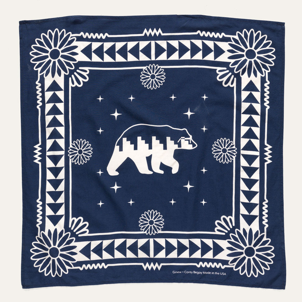 Full view of Naasgó Bandana which is navy and features a cream pattern around the borders and a side view of a bear in the center.