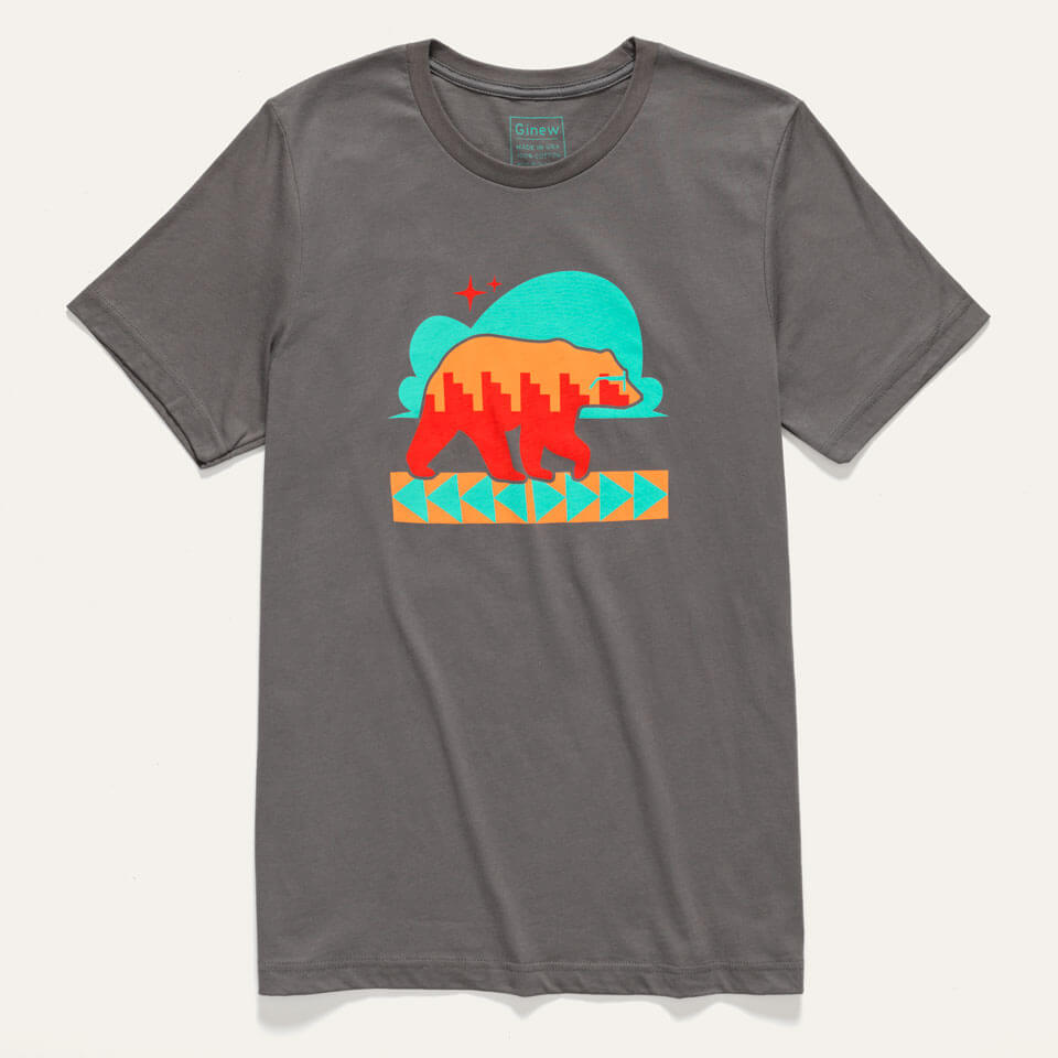 A grey tee shirt with Naasgo/Forward movement bear print in turquoise, orange, and red ink is shown on a male model standing in front of a neutral background.