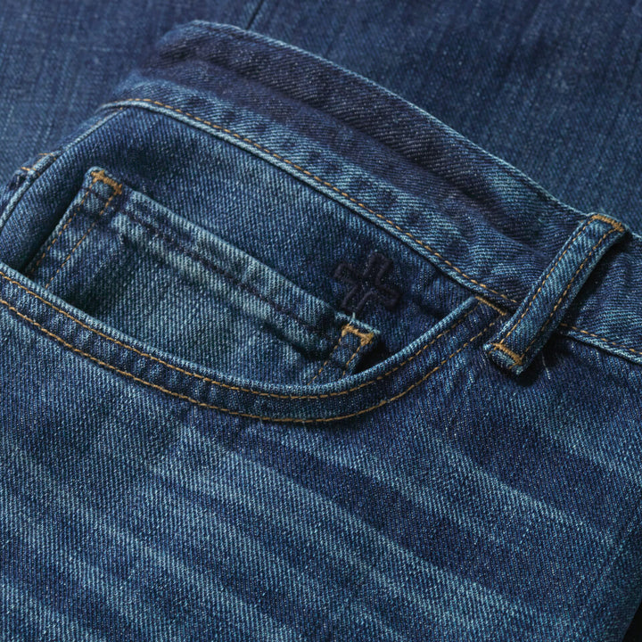 Close up of front right pocket that features a dark navy embroidered cross above the small watch pocket.