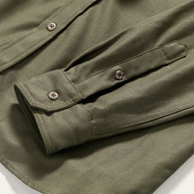 A close-up of an Army green button up Utility Shirt sleeve. Sleeve has a brown button closures.