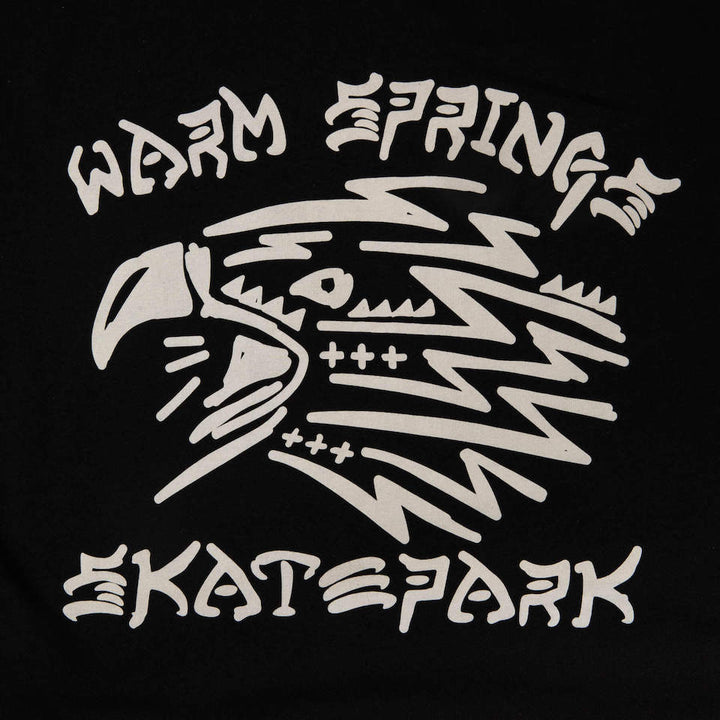 Black tee shirt with off-white design of the head of an eagle and the words Warm Spring Skate Park, close up of the graphic on the tee.