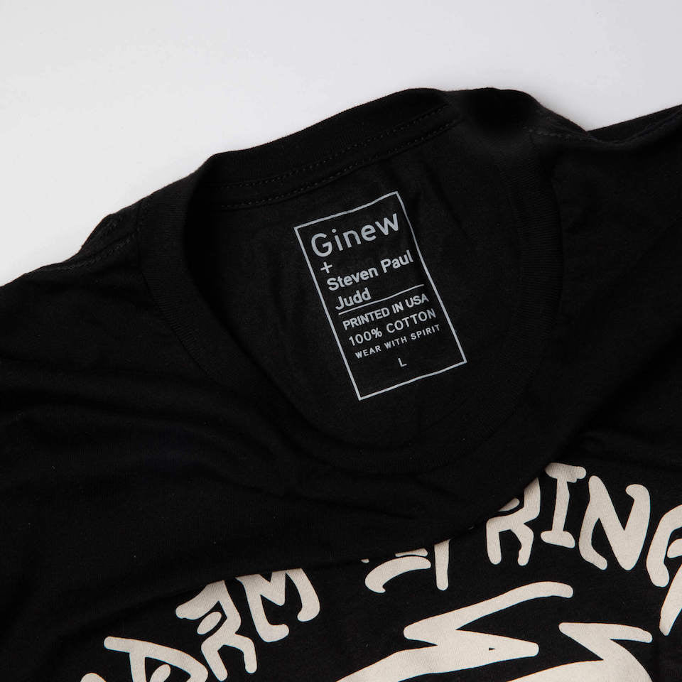 Close up of the tag of the shirt that says Ginew + Steven Paul Judd.
