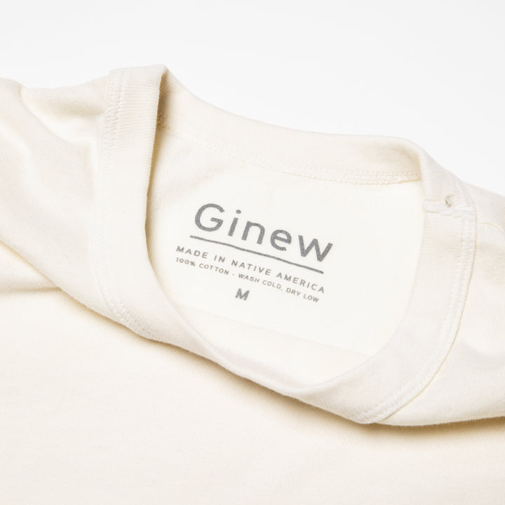 White cotton tshirt. The label says "Ginew. Made in Native America. 100% cotton. 