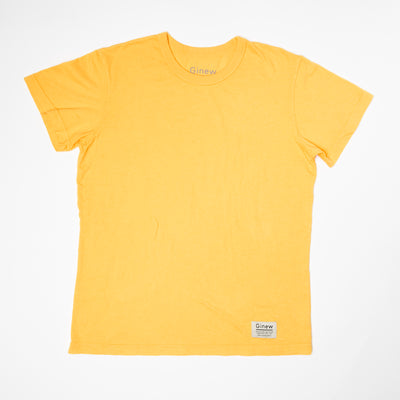 A crew t-shirt in a marigold yellow color is laid flat on a white background. The shirt has a white tag at the bottom left hem with the word Ginew on it.
