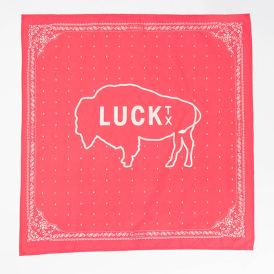 coral pink bandana with white design of an outline of a buffalo and the words Luck TX