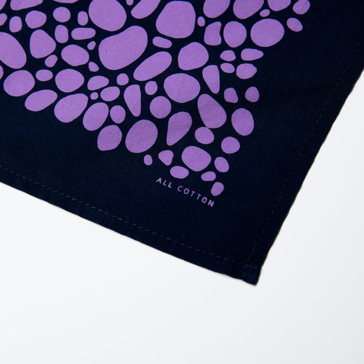 Close-up of bandana with blue, purple, and black Superior print on white background.