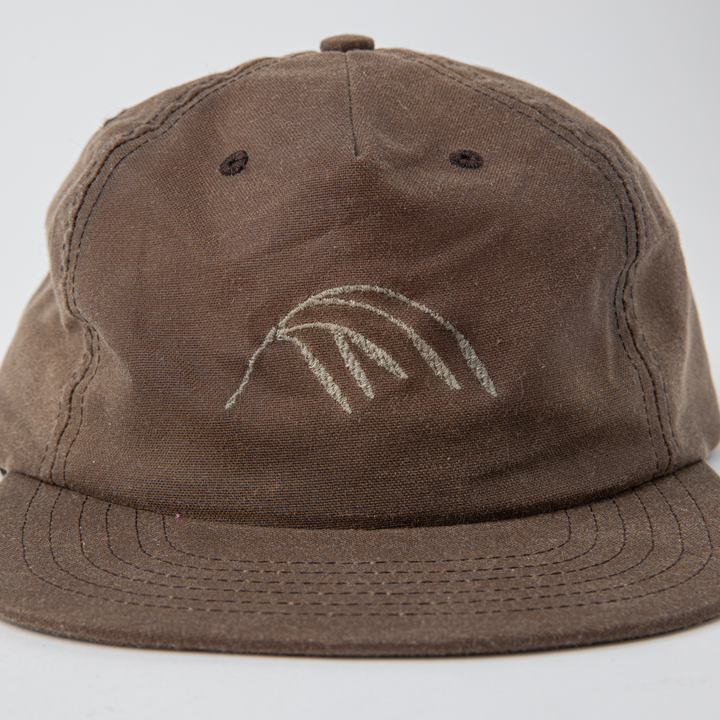 A light brown waxed canvas ball cap featuring a Crow Wing stitching in beige thread at the center front panel. Shown on a white background.