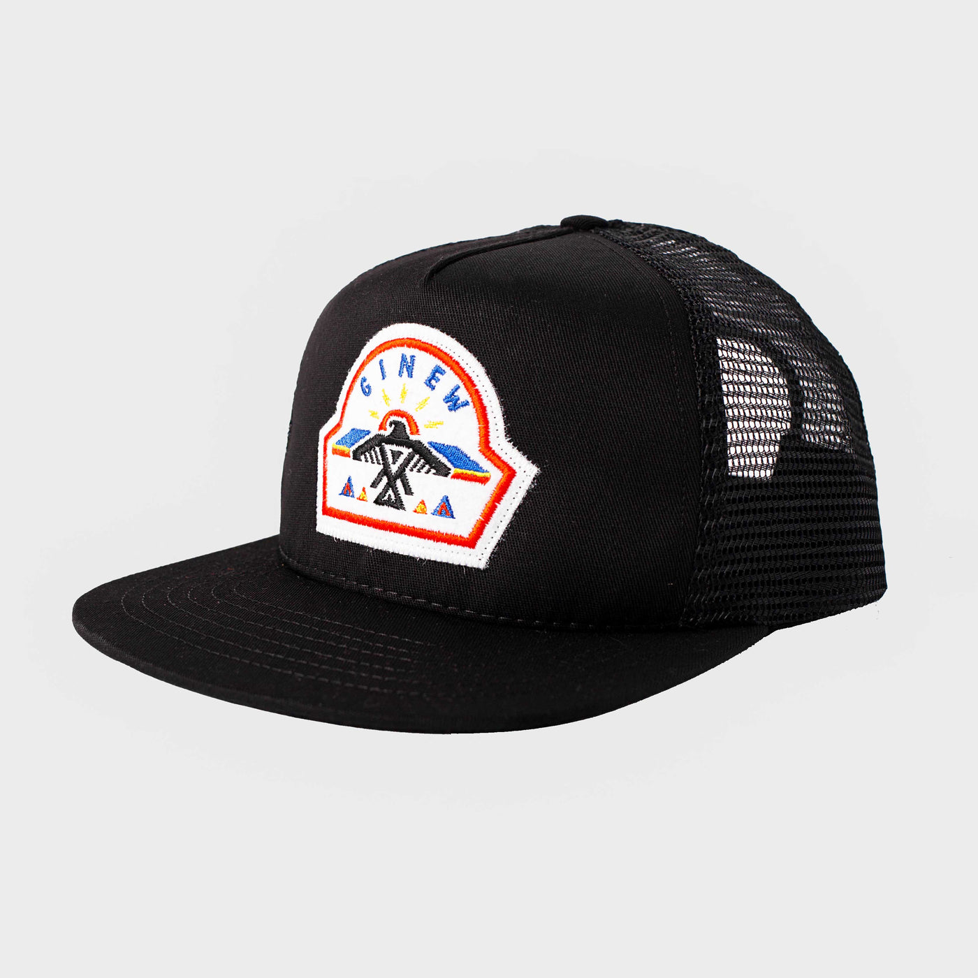 A black Trucker Hat with a white Ginew patch sewn at center front is shown on a white background. The patch features a thunderbird design stitched from blue, black, red, yellow, and orange thread.